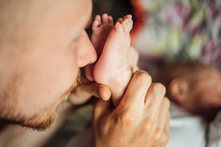 Dad holding Newborn baby heels in his handsの写真素材