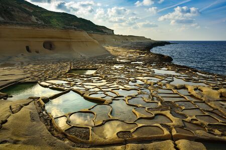 Salt evaporation pans on Malta. Ponds near sea filled with water at sunny day, february 2019の写真素材