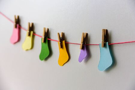 World Prematurity day concept. Normal size and Tiny socks on a red ropeの写真素材