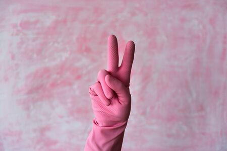 Pink left hand in V sign peace gesture. Left hander day conceptの写真素材
