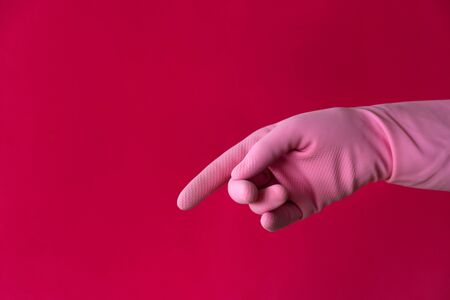 Pink pointing hand gesture on red. Left hander day conceptの写真素材