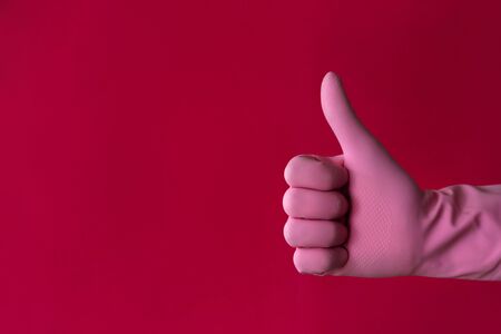 Pink hand thumb-up gesture on red. Left hander day conceptの写真素材