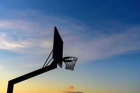 Street basketball hoop on sunset sky. Goal and win conceptの写真素材