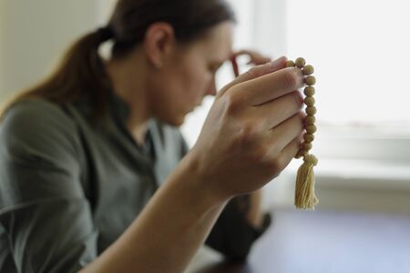 Paying woman with beads at homeの写真素材