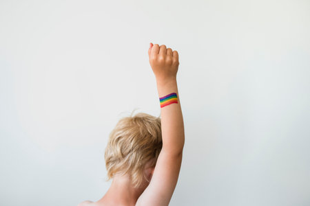 Rised child hand with rainbow LGBTQ pride flag tattoo. Movement symbolの写真素材