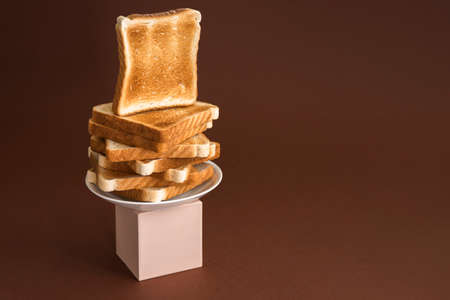 Heap of toasts on pedestal on brown. Modern still life, breakfastの写真素材
