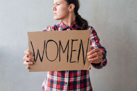 Woman activist with poster near concrete wall on street. For women rightsの写真素材