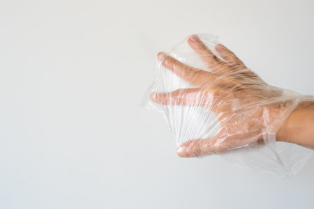 Hand holding inflated plastic bag. Microplastic pollution conceptの写真素材