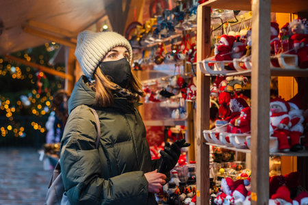 Woman in face mask on Christmas shopping on market in Tallinn, Estoniaの写真素材