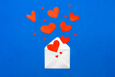 Envelope with red hearts on blue background. Valentines day