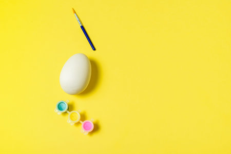 Easter egg painting set. Brush and paint on yellow background