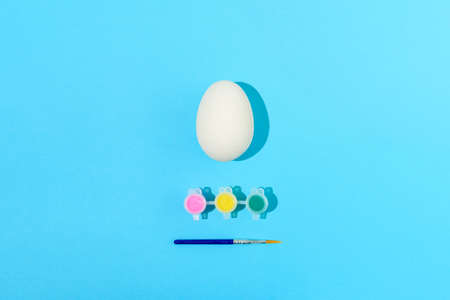 Easter egg painting set. Brush and paint on light blue backgroundの写真素材