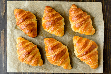 Fresh baked puff pastry croissants on baking paper