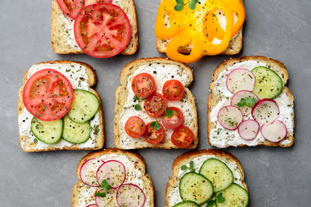 Healthy vegetarian sandwiches with vegetables - yellow pepper, tomato, cucumber and radish. Cream cheese and microgreensの写真素材