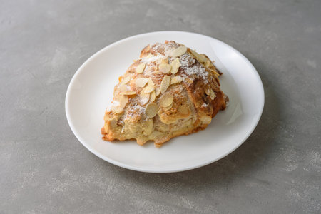 Almond croissant on plate with powdered sugar