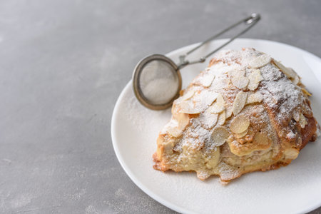 Almond croissant on plate with powdered sugar