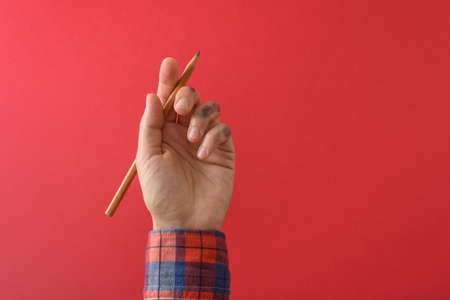 Dirty left hand in red shirt after writing. Left hander day concept.の写真素材