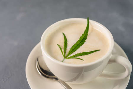 Hot Coffee drink with cannabis leaf on top of foamの写真素材