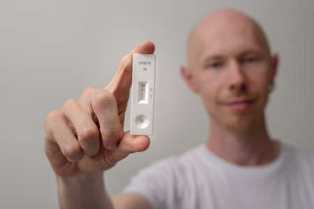Man with negative antigen covid test in handの写真素材