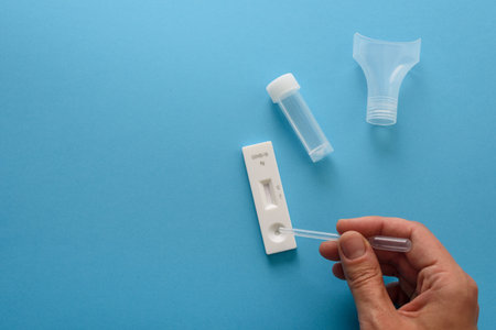 Hand making antigen covid test with pipette and salivaの写真素材