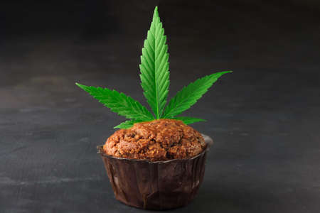 Chocolate muffin or cake with cannabis leaf, cbd infusedの写真素材