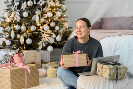 Woman with laptop, Christmas gifts and decorations. Buying or ordering onlineの写真素材