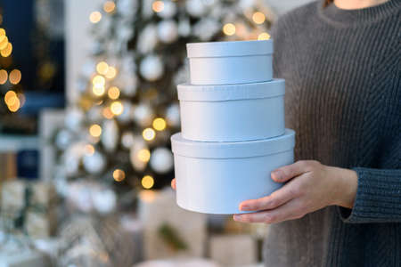 Woman holding stack gift boxes with Christmas decorationsの写真素材