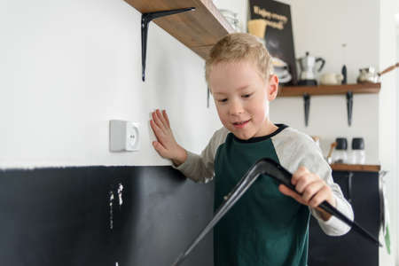 Boy child using screwdriver to renovation works at home kitchenの写真素材