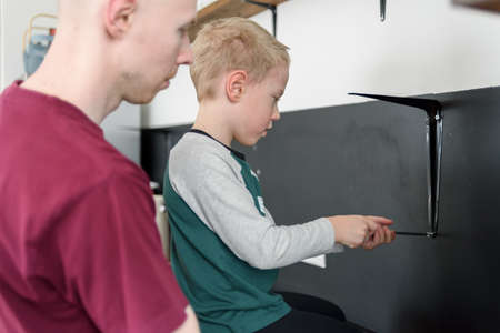 Father and son doing house renovations together. Using screwdriver. Dad teaching child to use toolsの写真素材