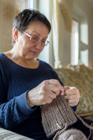 Mature woman knitting hat and relaxing