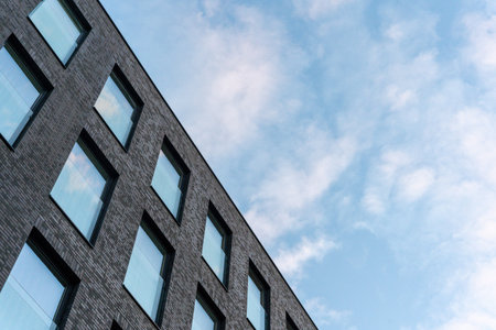 Modern unrecognised buildings with sunset sky reflected in window glasses