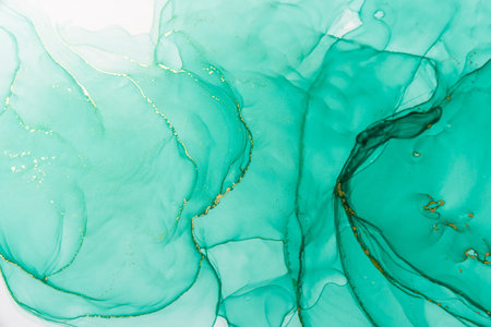Abstract alcohol ink fluid art background. Green color with goldの写真素材