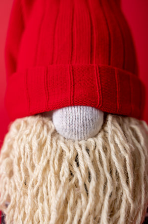 Handmade Christmas gnome on red background. Upcycle, made from old socks. Close up verticalの写真素材