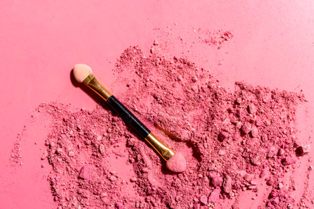 Crushed pink eye shadows with applicator blending brush or tool on pink backgroundの写真素材