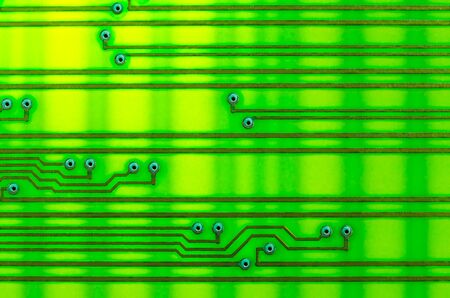 Circuit board as an abstract background, shot with backlight on the lumen. Yellow-green shades,...