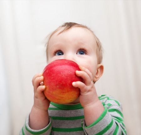Little baby with red appleの写真素材
