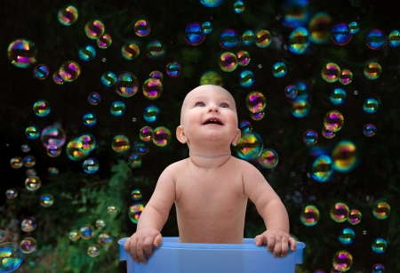Laughing baby surrounded by bubblesの写真素材