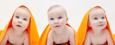 three babyss with orange towel