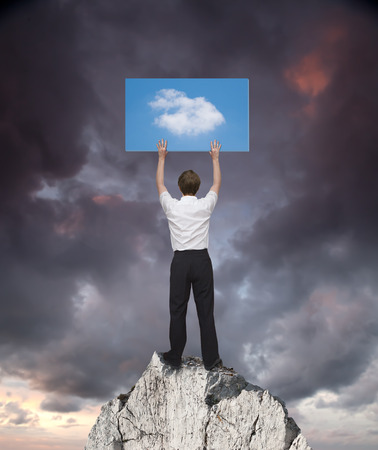 man on a rock trying to change the weatherの写真素材