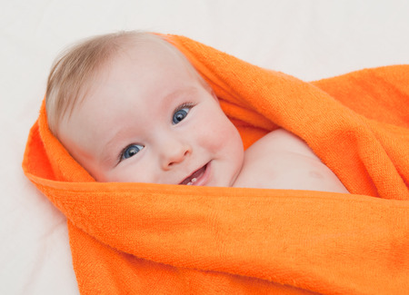  baby in orange towelの写真素材