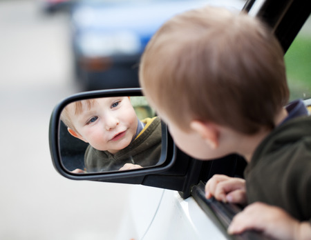 Small child looking to outside mirrorの写真素材