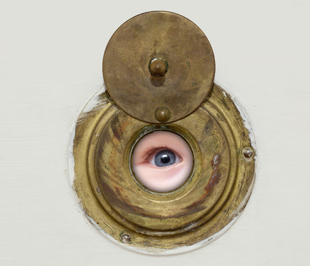 blue eye looking through the peephole door