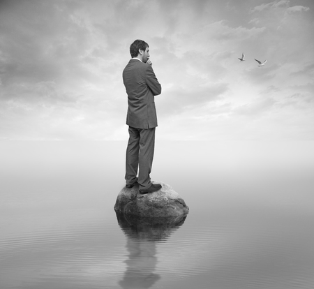 man on a rock in the middle of the lakeの写真素材