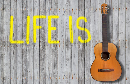 hite sign with life on a wooden fence and a guitarの写真素材