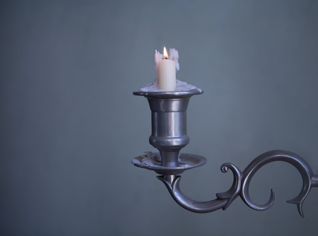 old candlestick with burning wax candleの写真素材