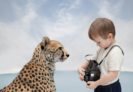 Little boy with old camera photographs big catの写真素材