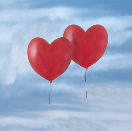 Two red balloons flying in the skyの写真素材
