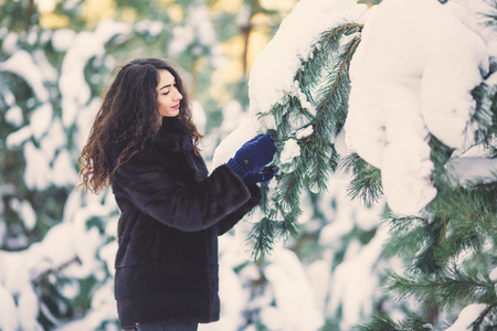Beautiful young girl in a snowy winter forestの写真素材