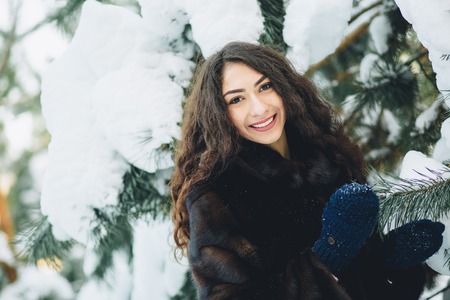 Beautiful young girl in a snowy winter forest