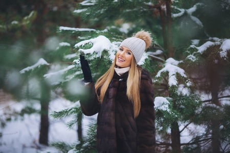 Young model girl walk in the winter forest with snow covered branches.の写真素材